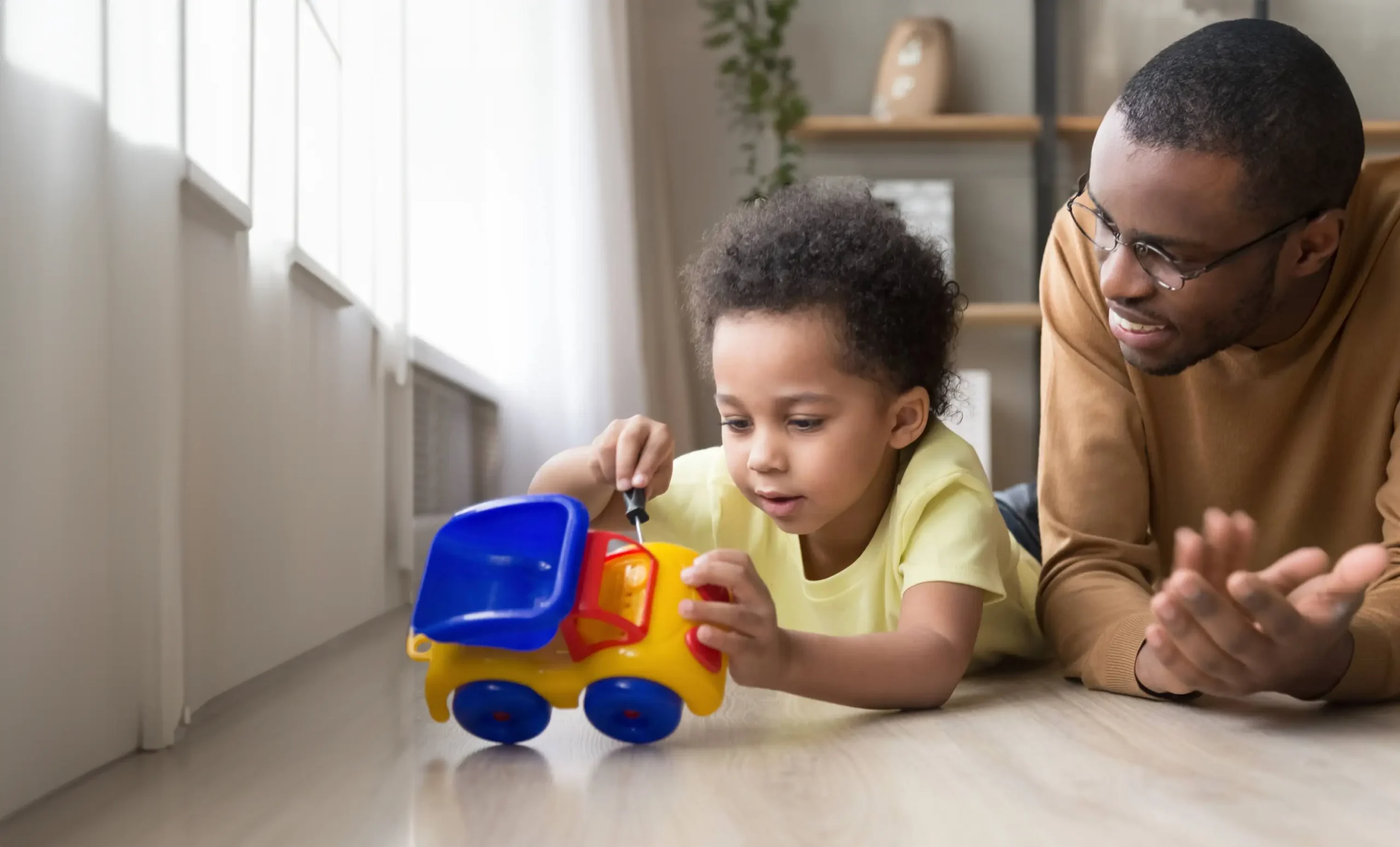 child fixing toy with father