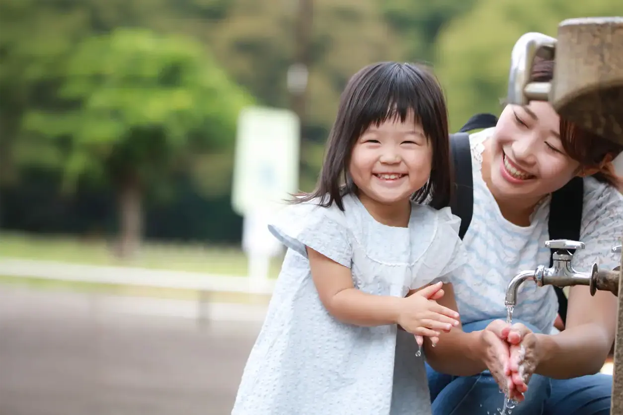 girl with mom at water fountain