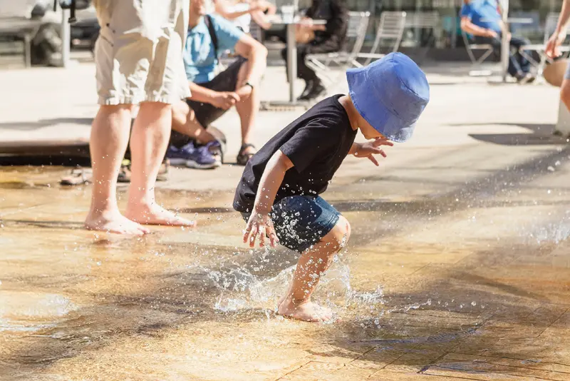 young child playing in splash pad
