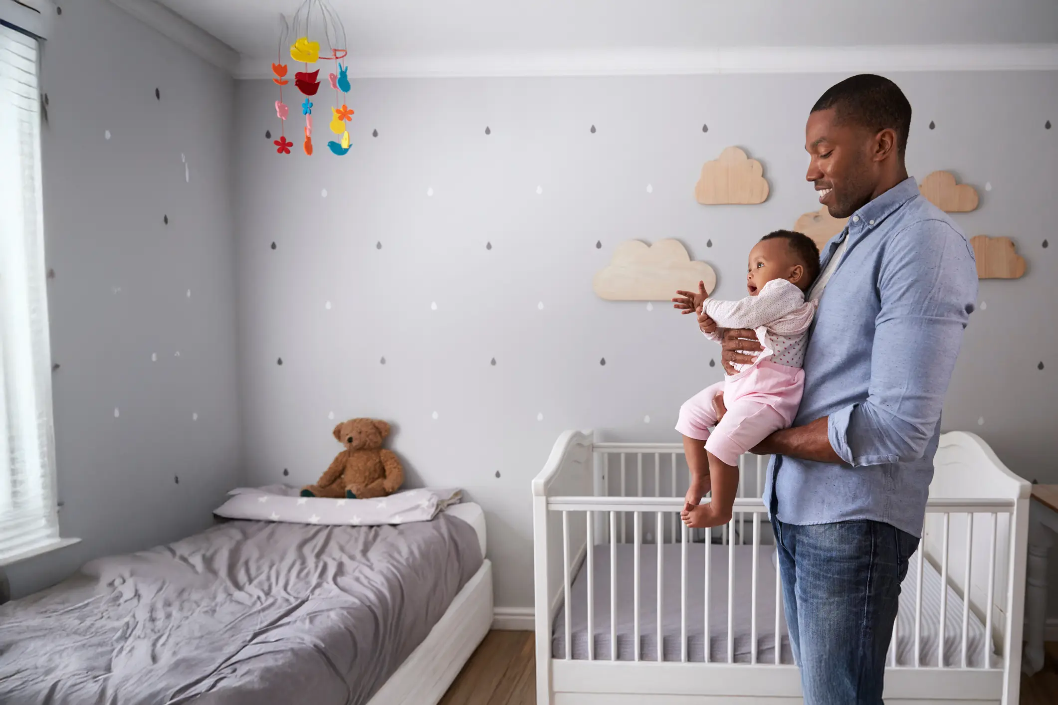dad holding young child in nursery