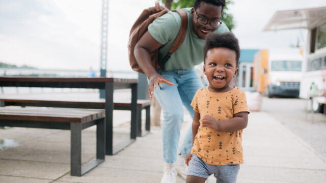 Young child running and playing with caregiver