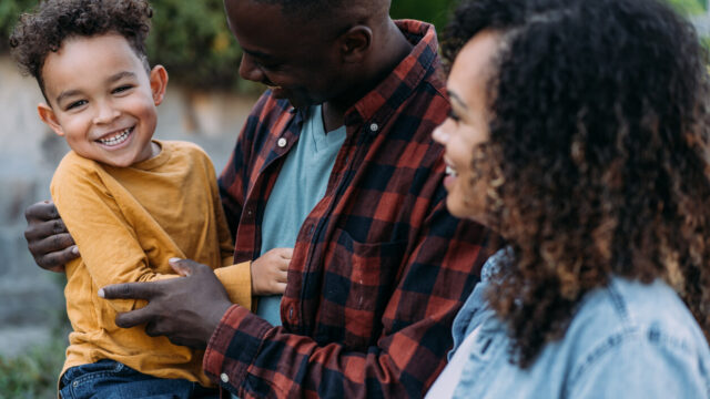 Young child playing with two caregivers