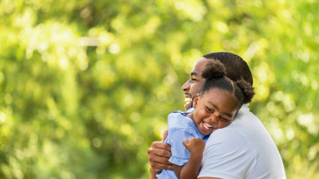 Caregiver holding and hugger toddler