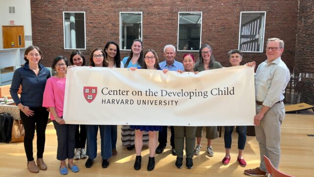 Center staff holding up a sign with our logo on it