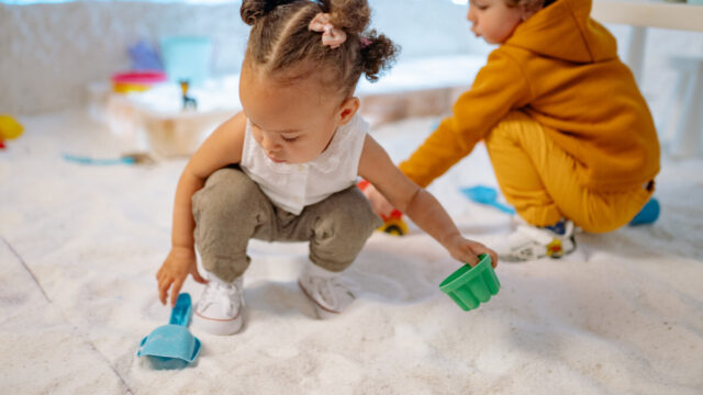 Two children playing in a sandbox