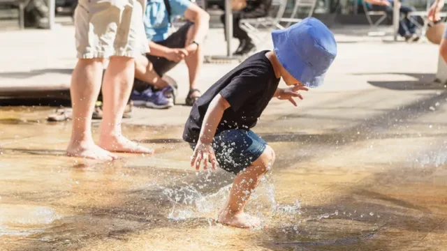 young child playing in splash pad.